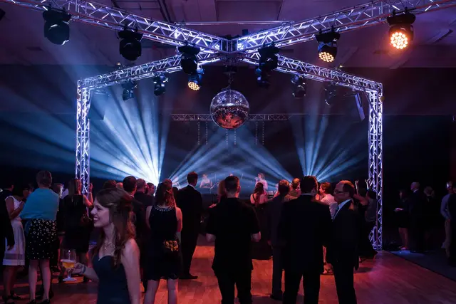 Ballsaal mit Discokugel, Gäste bei einer Firmengala im Halbdunkel