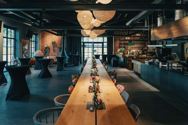 Loungebereich mit langer Tafel, warmes Licht