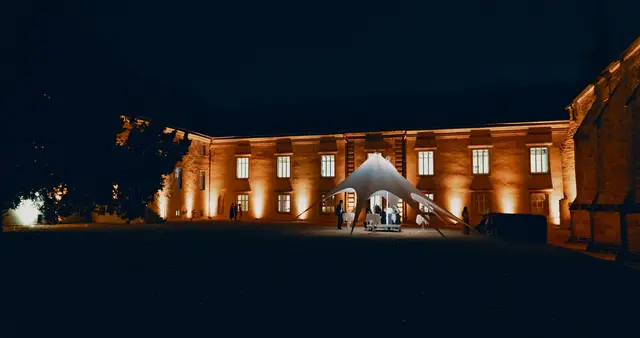 Sternzelt im Hof eines angestrahlten Gutshauses bei Nacht