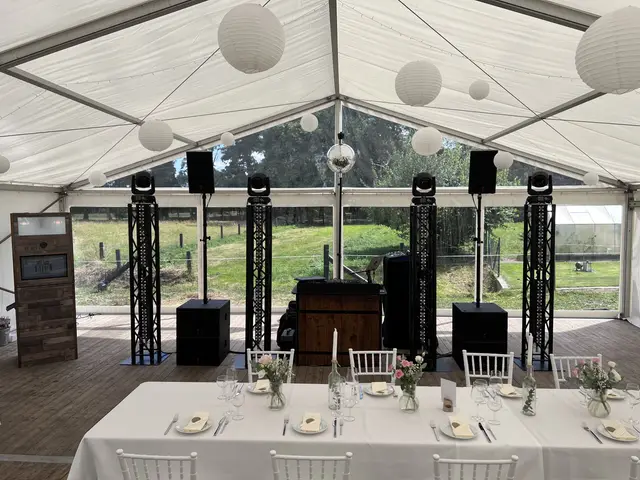 Truss Tower black im Zelt bei Tageslicht, gedeckter Hochzeitstisch im Vordergrund